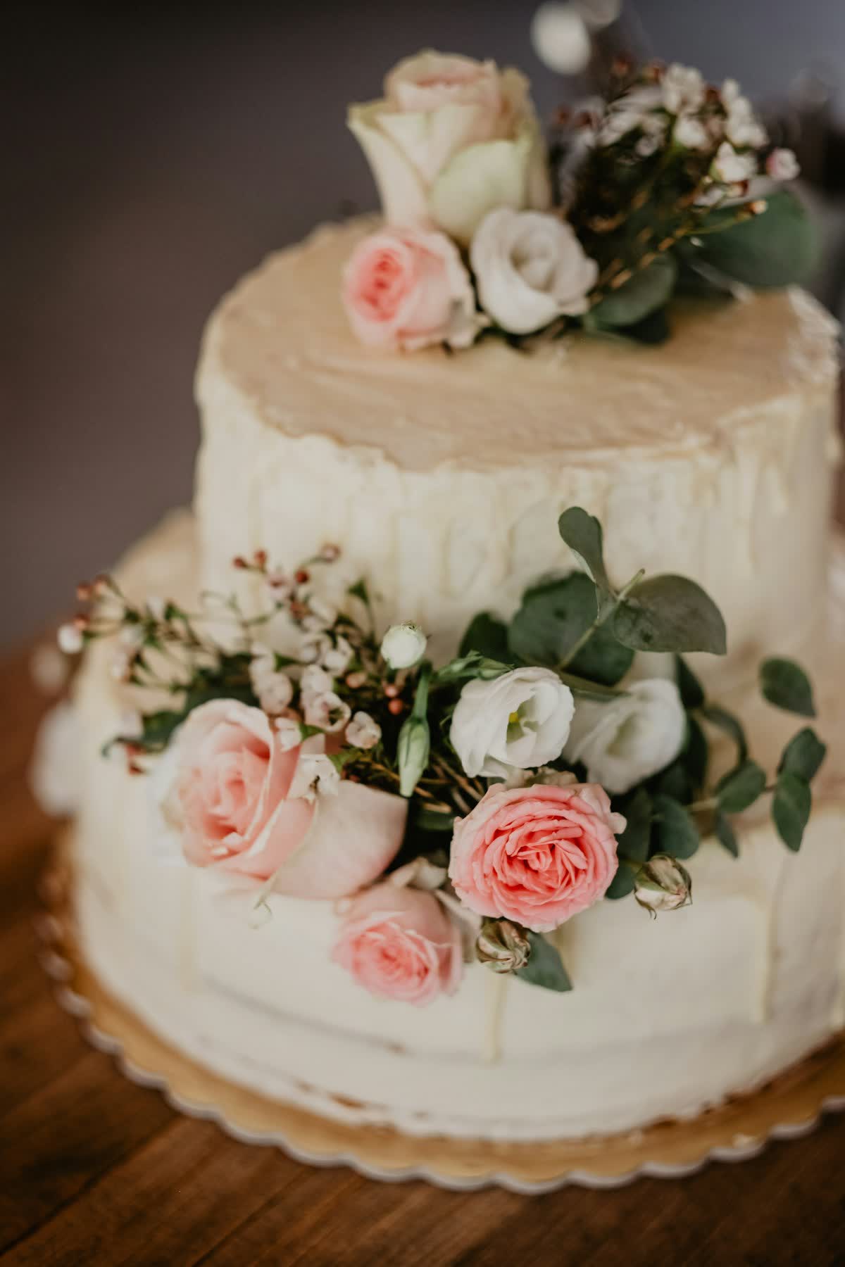 Two-tier buttercream cake crowned with fresh roses