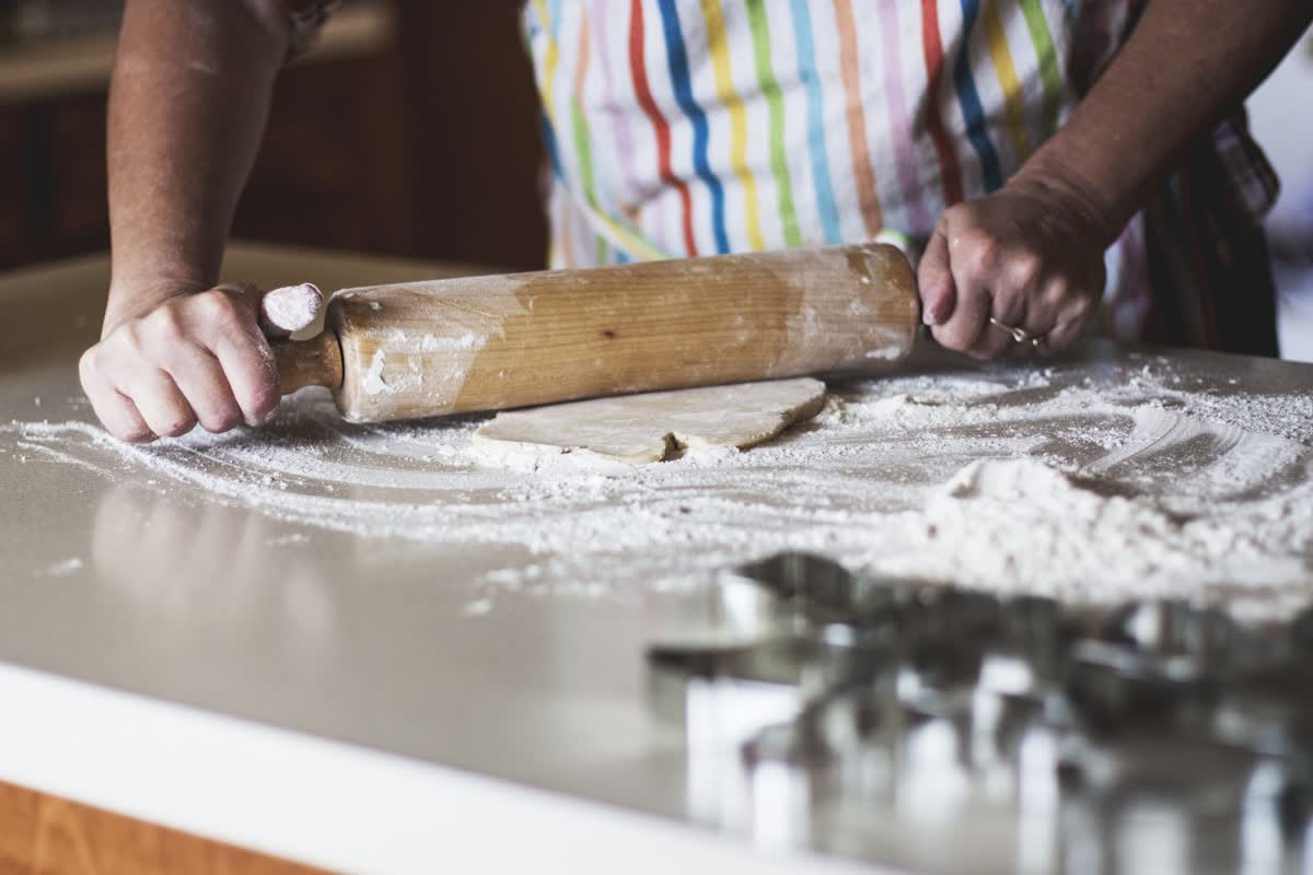 Rolling pin, flour and cookie cutters on a worktop