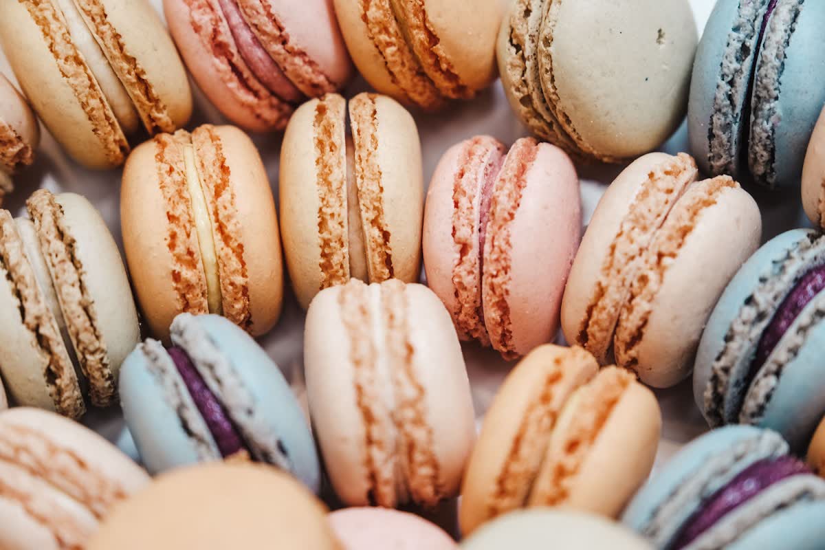 Rows of delicate macarons in warm caramel and cream shades
